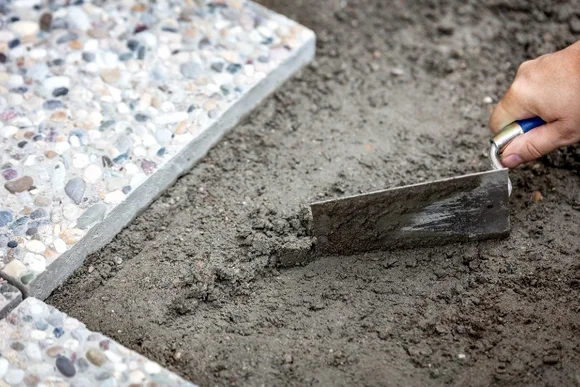 Hand verteilt Mörtel mit Kelle